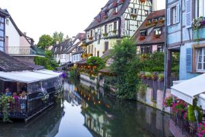 un canal en una ciudad con edificios y un barco en Ferienwohnung Weyl, en Eschbach