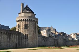 una torretta del castello con una città sullo sfondo di chambre au calme a Botquelen ad Arradon