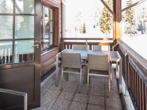 een tafel en stoelen op een balkon met een deur bij Holiday Home Point vale 2 ap- 5 by Interhome in Tahkovuori
