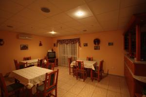 a dining room with tables and chairs and a television at Rózsa Vendégház in Dunaszentmiklós