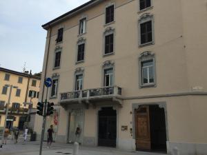 Un gran edificio blanco con un balcón a la calle. en Bergamo Center Rooms, en Bérgamo