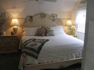 a bedroom with a large white bed with two lamps at Black Forest Bed & Breakfast in Helen