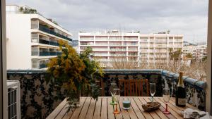 einen Balkon mit einem Tisch mit Weinflaschen und Gläsern in der Unterkunft Le Petit Magellan by Welcome to Cannes in Cannes