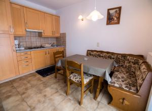 eine Küche und ein Esszimmer mit einem Tisch und einer Couch in der Unterkunft 689 Banjol in Rab