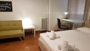 Habitación con cama, silla y escritorio. en Violet Errathens Apartment - Athens Center, 7 BD, 3 BATH en Atenas