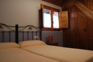 a bedroom with two beds and a window at Casa Rural Los Barreros in San Cristóbal de Segovia