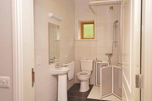 La salle de bains blanche est pourvue de toilettes et d'un lavabo. dans l'établissement Apartment 703 Letterfrack, à Letterfrack