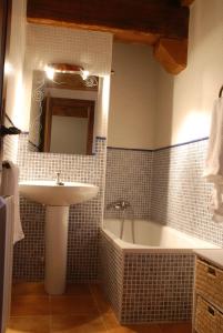 a bathroom with a sink and a bath tub at Casa Rural Los Barreros in San Cristóbal de Segovia