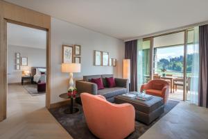 a living room with a couch and a table at Bürgenstock Hotels & Resort - Waldhotel & Spa in Bürgenstock