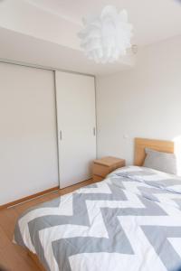 ein Schlafzimmer mit einem großen Bett und einem Kronleuchter in der Unterkunft Quiet & Modern Downtown 1BR, near Bus Station & Airport in Tallinn