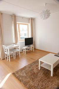 ein Wohnzimmer mit einem Tisch und einem TV in der Unterkunft Quiet & Modern Downtown 1BR, near Bus Station & Airport in Tallinn
