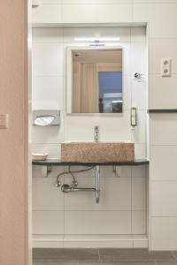 a bathroom with a sink and a mirror at Insel-Hotel-Lindau in Lindau