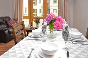 a table with plates and bowls and flowers on it at Apartment 704 Letterfrack in Letterfrack