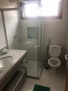 a bathroom with a shower and a toilet and a sink at Bali Bahia Itacimirim in Itacimirim