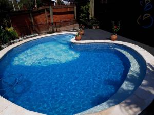 a large pool with blue water in a backyard at Sentirse en casa in Puerto Iguazú