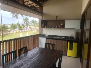 a dining room with a table and a view of a golf course at Bali Bahia Itacimirim in Itacimirim