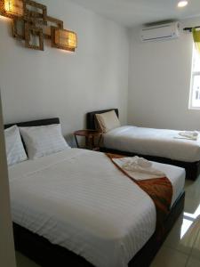 a hotel room with two beds and a window at Art Villa in Alor Setar