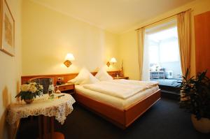 a hotel room with a bed and a table at Hotel Binz in Bernkastel-Kues