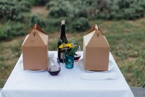 a table with a bottle of wine and two boxes at Collective Vail Retreat in Wolcott