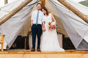 a bride and groom standing in front of a tent at Collective Vail Retreat in Wolcott