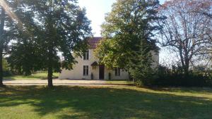 una casa blanca con árboles delante de ella en Le Pontet, en Miramont-de-Guyenne