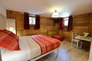 a bedroom with a bed and a desk in a room at Hotel Petit Dahu - Chambres et Restaurant in Cogne