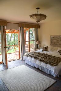 um quarto com uma cama e uma grande janela em ALEHUE Casa de Montaña em Villa La Angostura