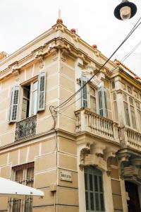 an old building with a balcony on a street at The Urban Jungle Hostel in Málaga