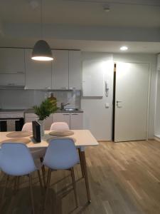 une cuisine avec une table et deux chaises ainsi qu'une porte dans l'établissement Siljo Apartments, à Rovaniemi
