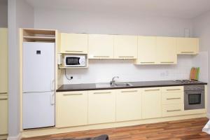 a kitchen with white cabinets and a white refrigerator at Apartment 707 Letterfrack in Letterfrack