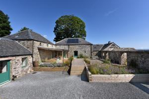 an external view of a stone house with a garden at Burmieston in Perth