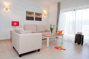 a living room with a white couch and a table at Sagres Time Apartamentos in Sagres