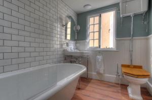 a bathroom with a tub and a toilet and a sink at Little Monmouth 4 bedroom cottage, Old town Lyme Regis, dog friendly and parking in Lyme Regis +25 photos