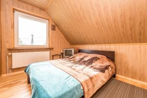 ein Schlafzimmer mit einem Bett in einem Zimmer mit einem Fenster in der Unterkunft Edmart in Dobromislė