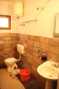 a bathroom with a toilet and a sink at Nature Care Village- Rajaji National Park in Rishīkesh +45 photos
