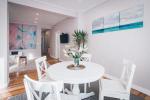 a white dining room with a white table and chairs at Garai Apartment by People Rentals in Bilbao