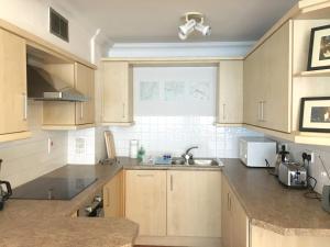 a kitchen with wooden cabinets and a sink and a window at Splendid Fitzrovia W1 Heart of Central London 1-Bed. Free Wifi in London