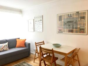 een woonkamer met een bank en een tafel en stoelen bij Splendid Fitzrovia W1 Heart of Central London 1-Bed. Free Wifi in Londen