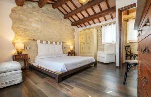 um quarto com uma cama e uma parede de pedra em Casamenetto Vacanze em Sassoferrato