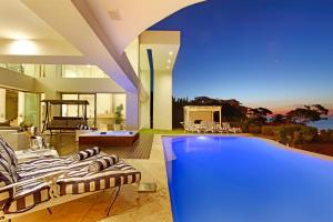 
a living room filled with furniture and a pool at Hollywood Mansion & Spa Camps Bay in Cape Town
