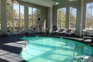 a large swimming pool in a building with windows at Country Inn & Suites by Radisson, Pigeon Forge South, TN in Pigeon Forge