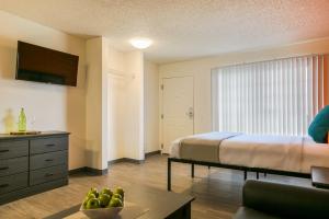 - une chambre avec un lit et une table avec un bol de fruits dans l'établissement Siegel Select Albuquerque 2, à Albuquerque