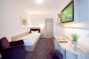 ein Hotelzimmer mit einem Bett und einem TV in der Unterkunft Hotel-Restaurant Birkenhof in Bad Soden-Salmünster