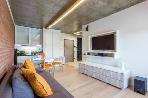 a living room with a couch and a tv and a table at Apartment Verde Trifoiului in Cluj-Napoca