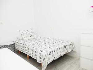 ein weißes Schlafzimmer mit einem Bett und einem Tisch in der Unterkunft Campanar Flat in Valencia