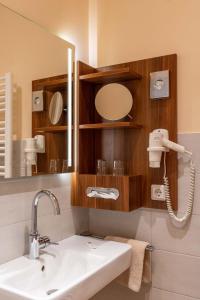 a bathroom with a sink and a mirror at Frommanns Landhotel in Buchholz in der Nordheide