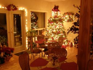 a christmas tree in a room with chairs and a table at Cedar Wood Lodge Bed & Breakfast Inn in Port Alberni