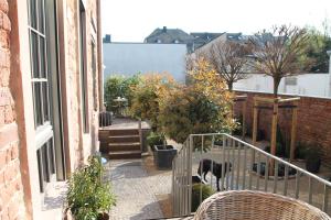 a balcony of a building with a cow walking down a street at Junior Suite The Backyard TBY 01 in Trier