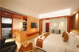 a bedroom with a large bed and a living room at Akhil Classic in Trivandrum