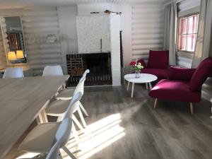 Hotelli Lepolampi في إسبو: غرفة معيشة مع طاولة وكراسي ومدفأة